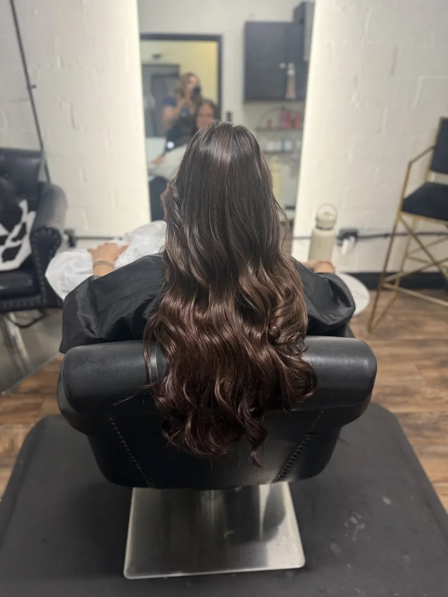 Long dark wavy hair styled by The Hair Court in Bryan-College Station, TX.
