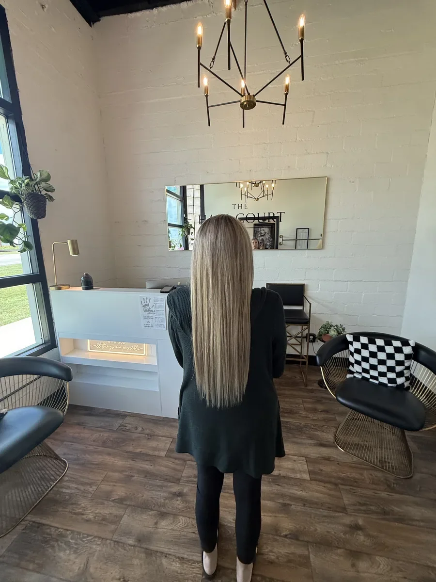Long blonde hair full-length view by The Hair Court in Bryan-College Station, TX.