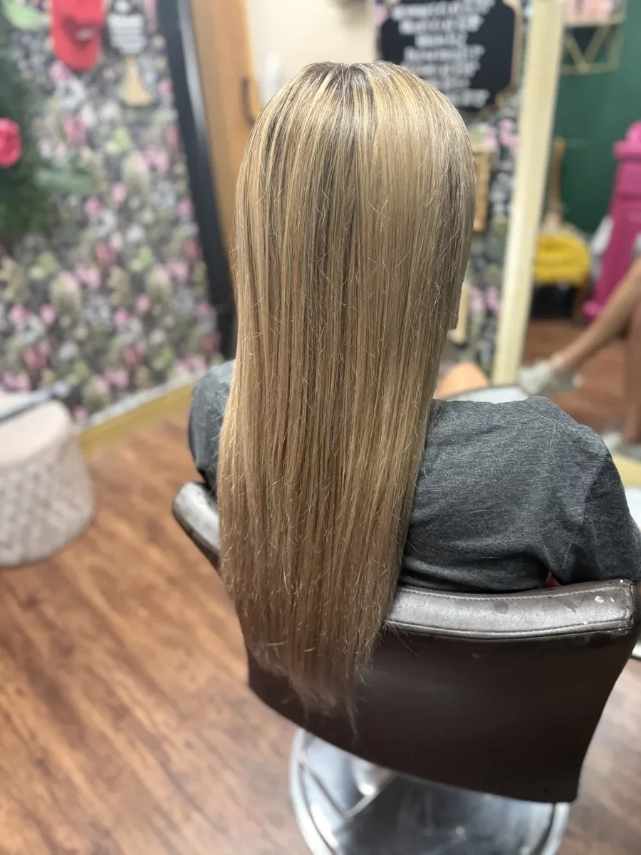 Long dimensional blonde straight hair by The Hair Court in Bryan-College Station, TX.