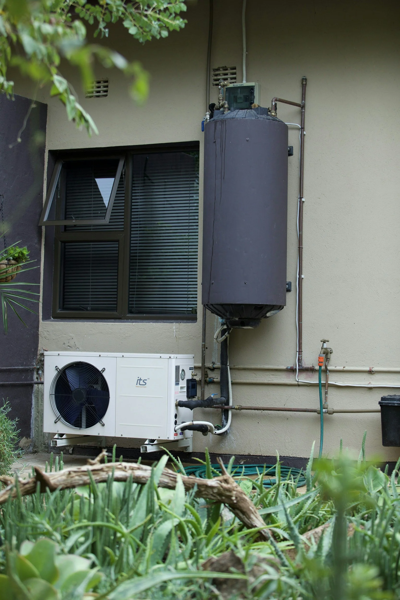 An air conditioning unit and a water heater installed outdoor in a home at Bendigo