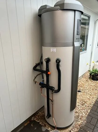 A gray water heater tank installed outdoors on a house in Bendigo