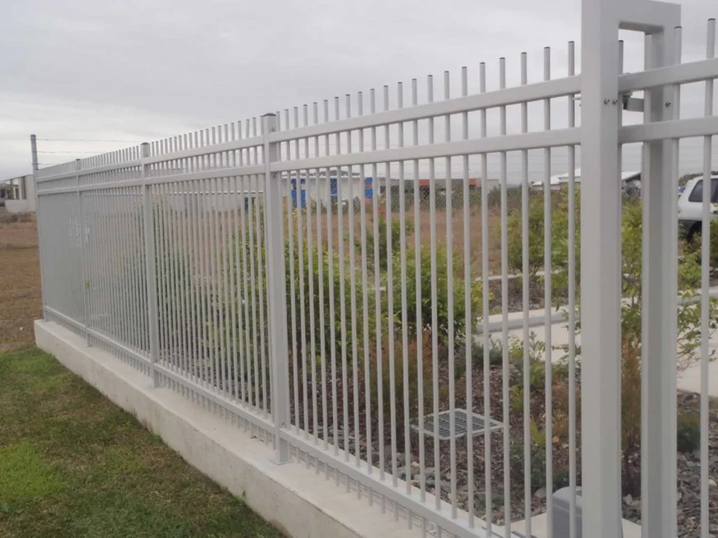 White metal fence with vertical bars installed by SWIFT