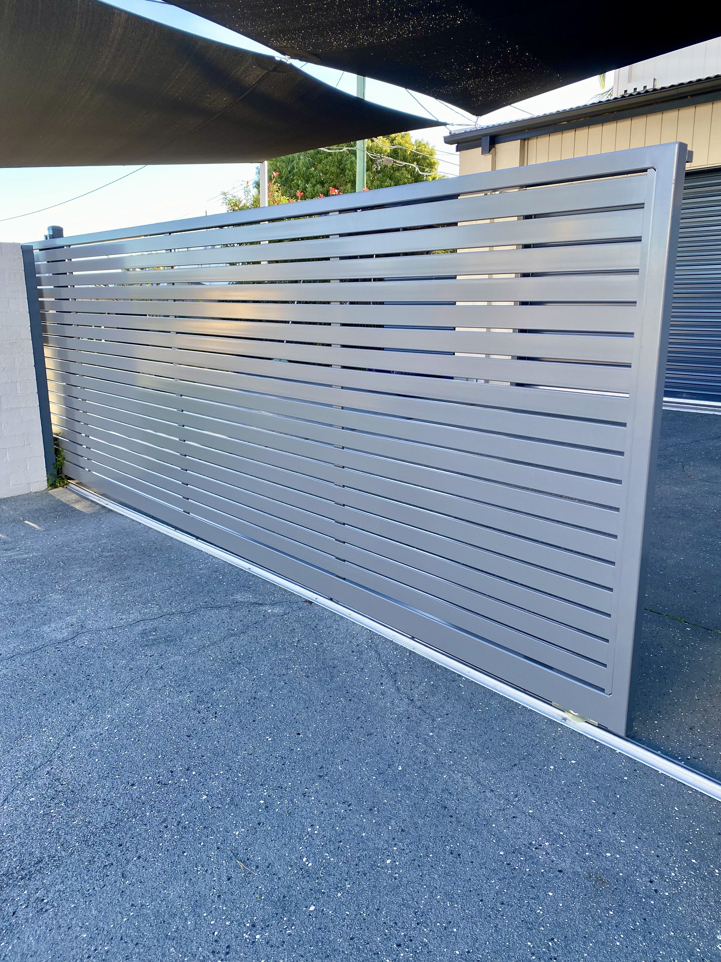 Grey slat front gate - manufactured and installed by Swift Powdercoating & Fencing Brisbane