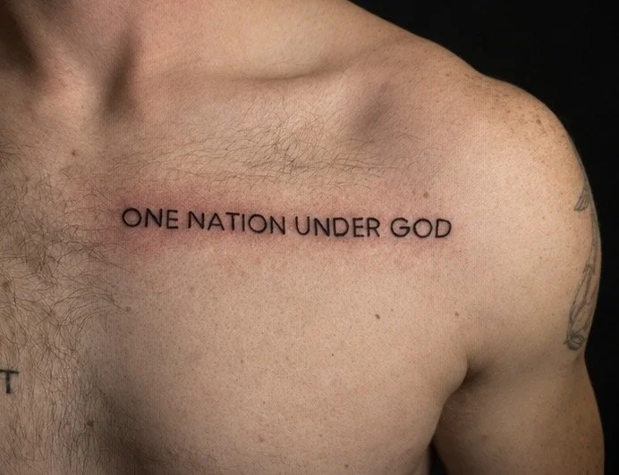 Tattoo on a person's chest that reads 'ONE NATION UNDER GOD'.