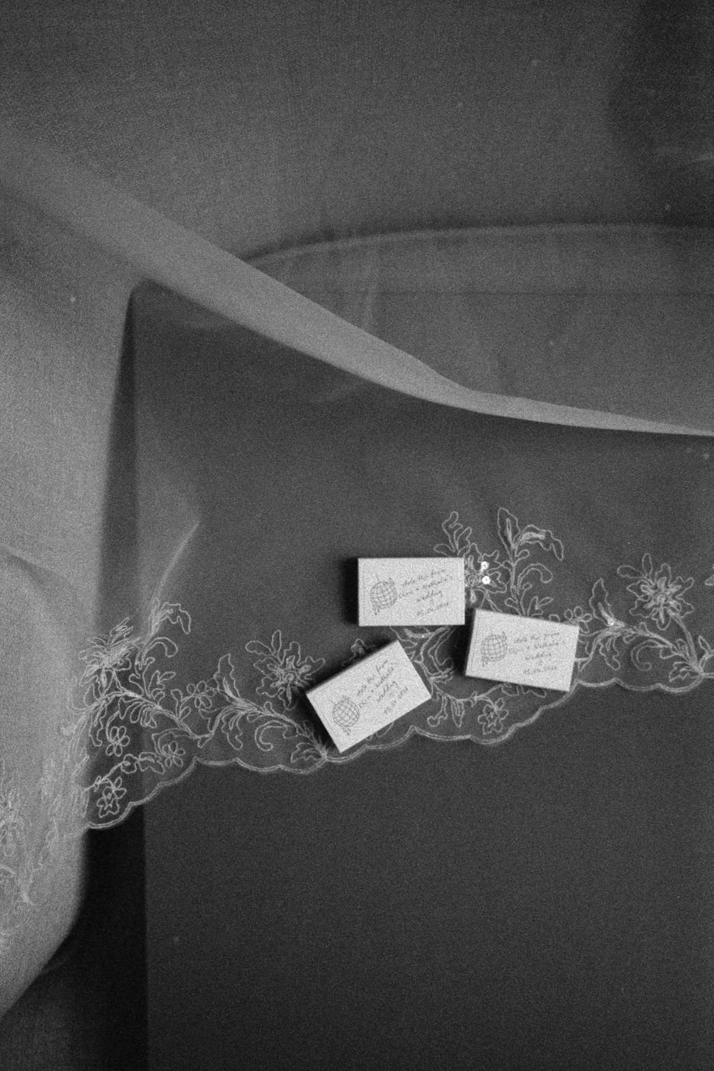Three small paper notes with handwritten text placed on a dark surface decorated with floral embroidery.