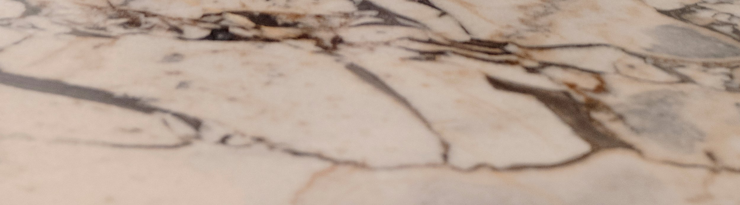 Close-up of a marble or stone surface with natural veining and coloration.