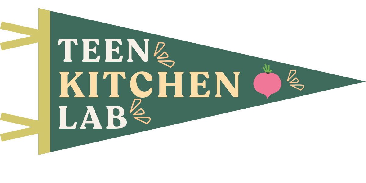 A green pennant banner with yellow ribbons saying 'Teen Kitchen Lab' and a pink radish decoration.