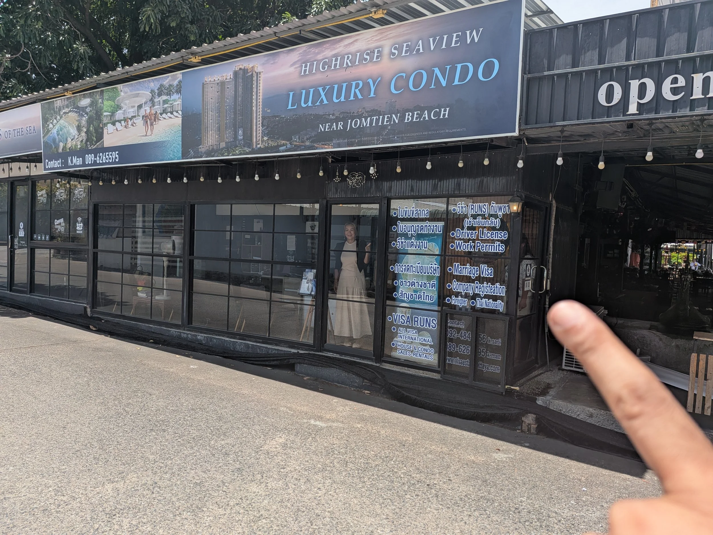 Sign advertising high-rise luxury condos near Jomtien Beach with contact information displayed.