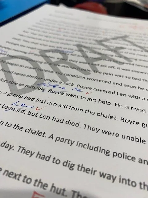 Close-up of a printed document with handwritten and checked annotations in blue and red ink.