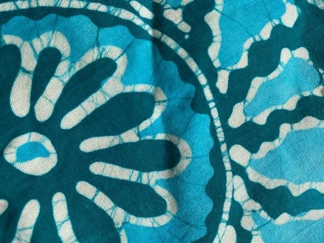 Close-up of a blue fabric with a white leaf pattern.