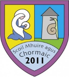 School crest with a spiral motif, a scroll, and the year 2011, featuring the Irish phrase 'Scoil Mhuire agus Chormaic'.