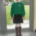A young girl standing in front of a glass door.