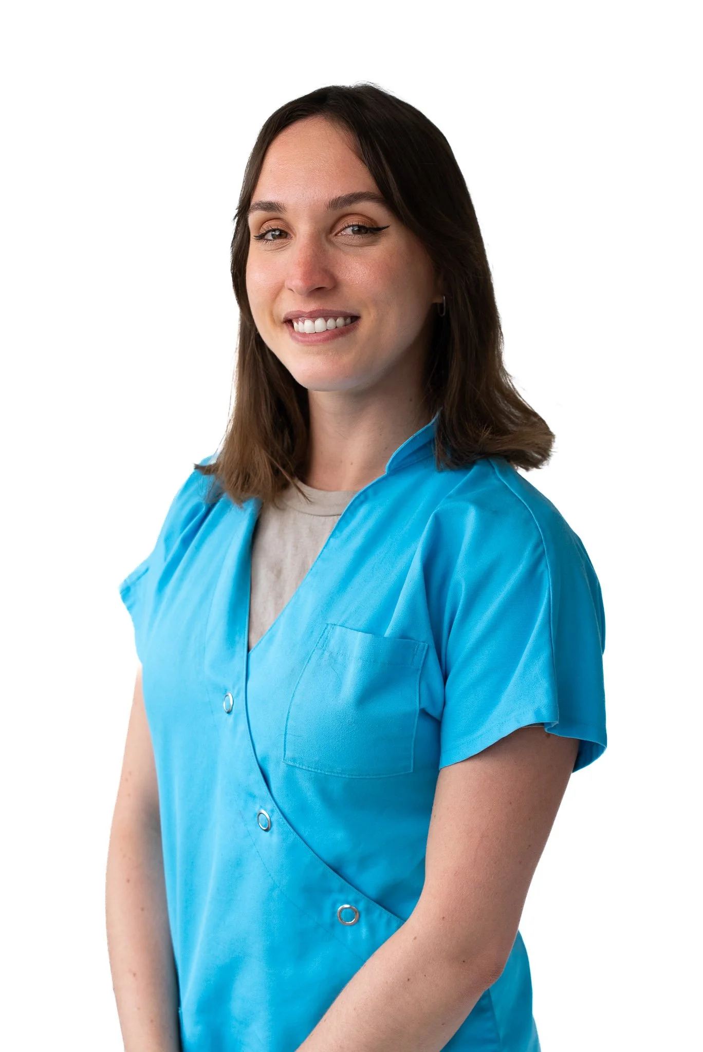 Staff member in light blue medical scrubs, smiling, white background.
