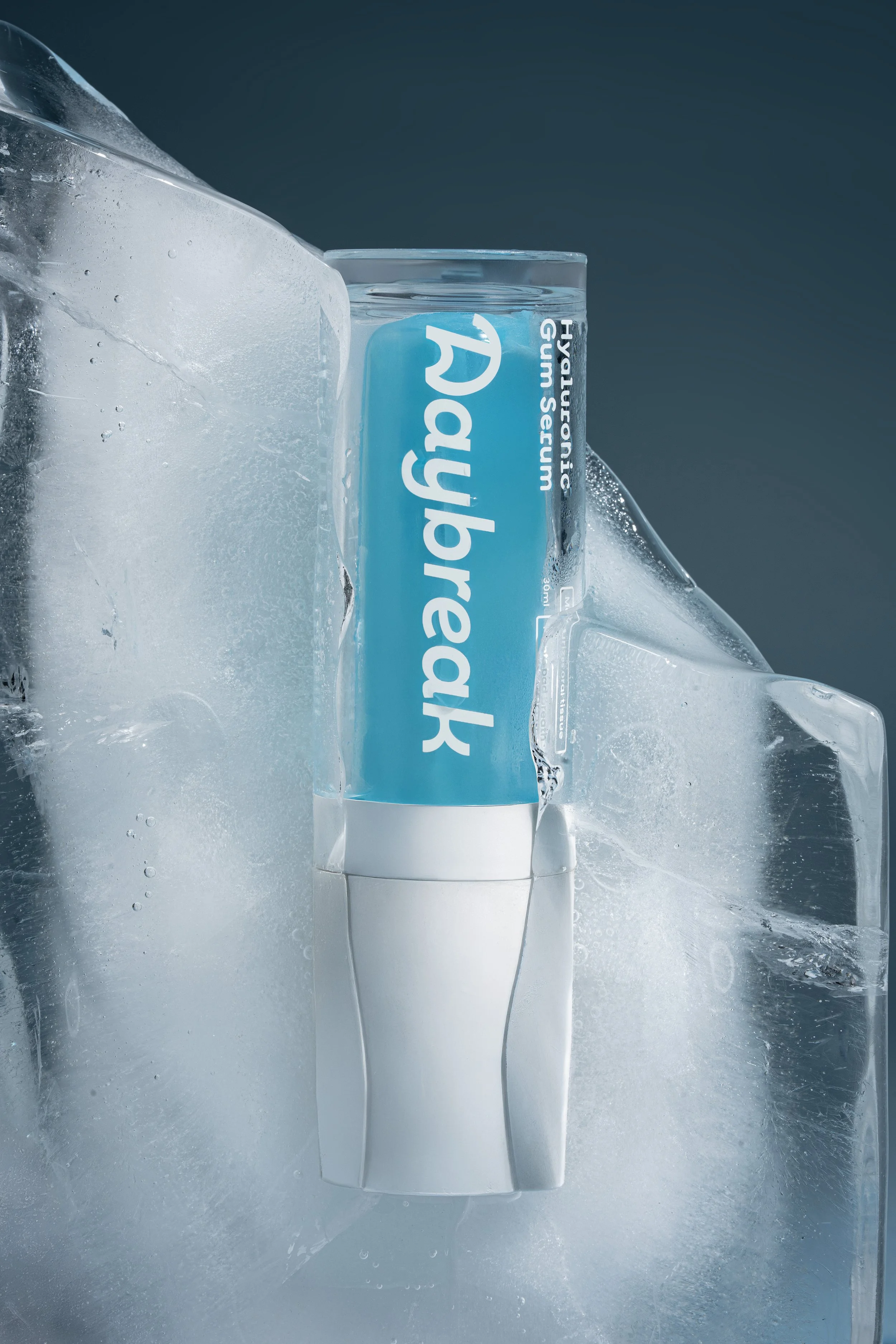 A tube of toothpaste on a reflective surface with ice surrounding it, labeled 'Toothpaste' and 'Hydration'