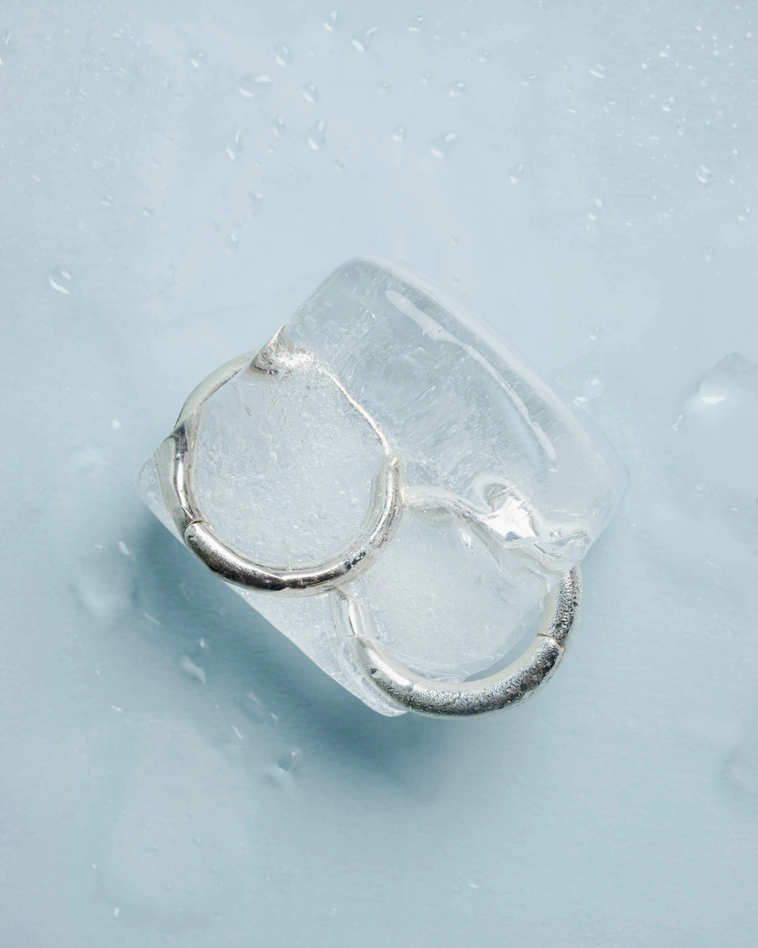 Close-up of a clear ice cube on a light blue background.