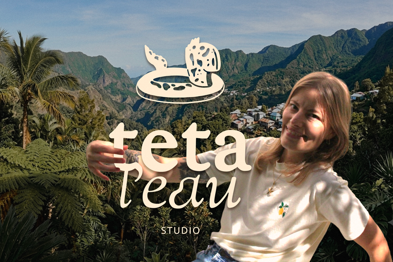 Le visuel avec la marque Tetal'eau en pleine nature réunionnaise : la créatrice du studio souriante en t-shirt jaune pastel tenant le logo de la marque Tetal'eau, avec en arrière-plan des montagnes, un ilet et une végétation tropicale luxuriante.