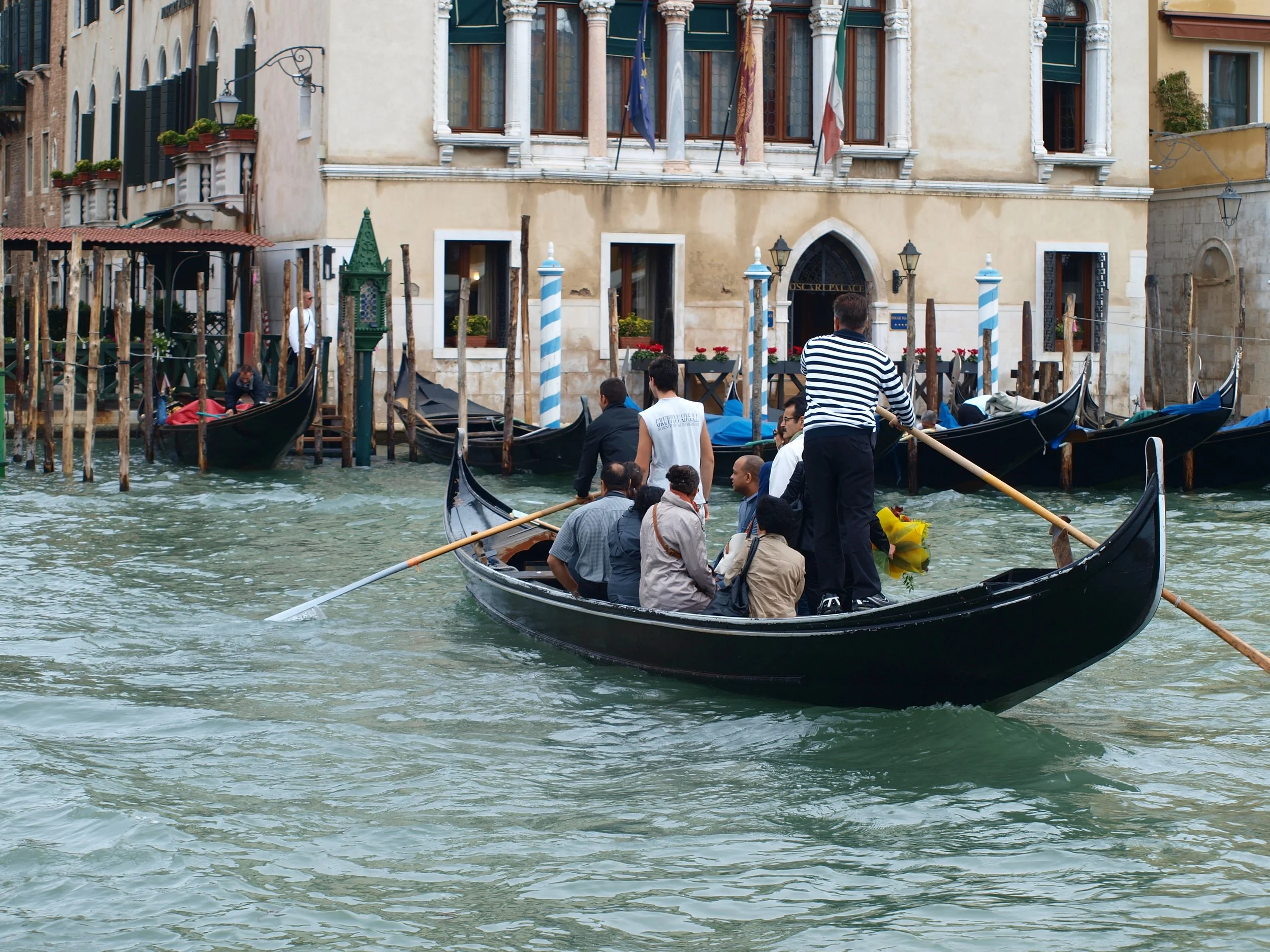 Gondoles naviguant sur un canal à Venise, Italie, avec des bâtiments historiques en arrière-plan.
