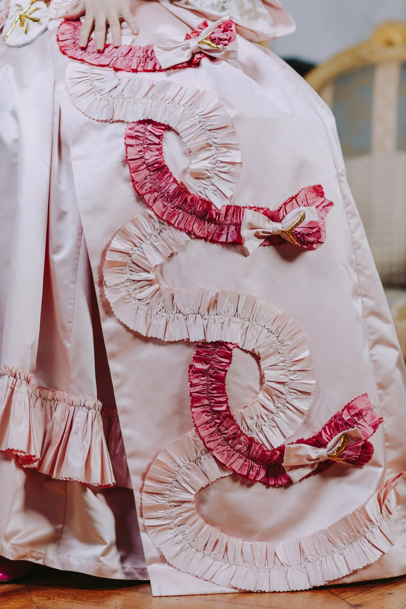 Détails couture ornements falbalas broderies rococo d'une jupe robe à la française 18ème siècle en satin de soie rose