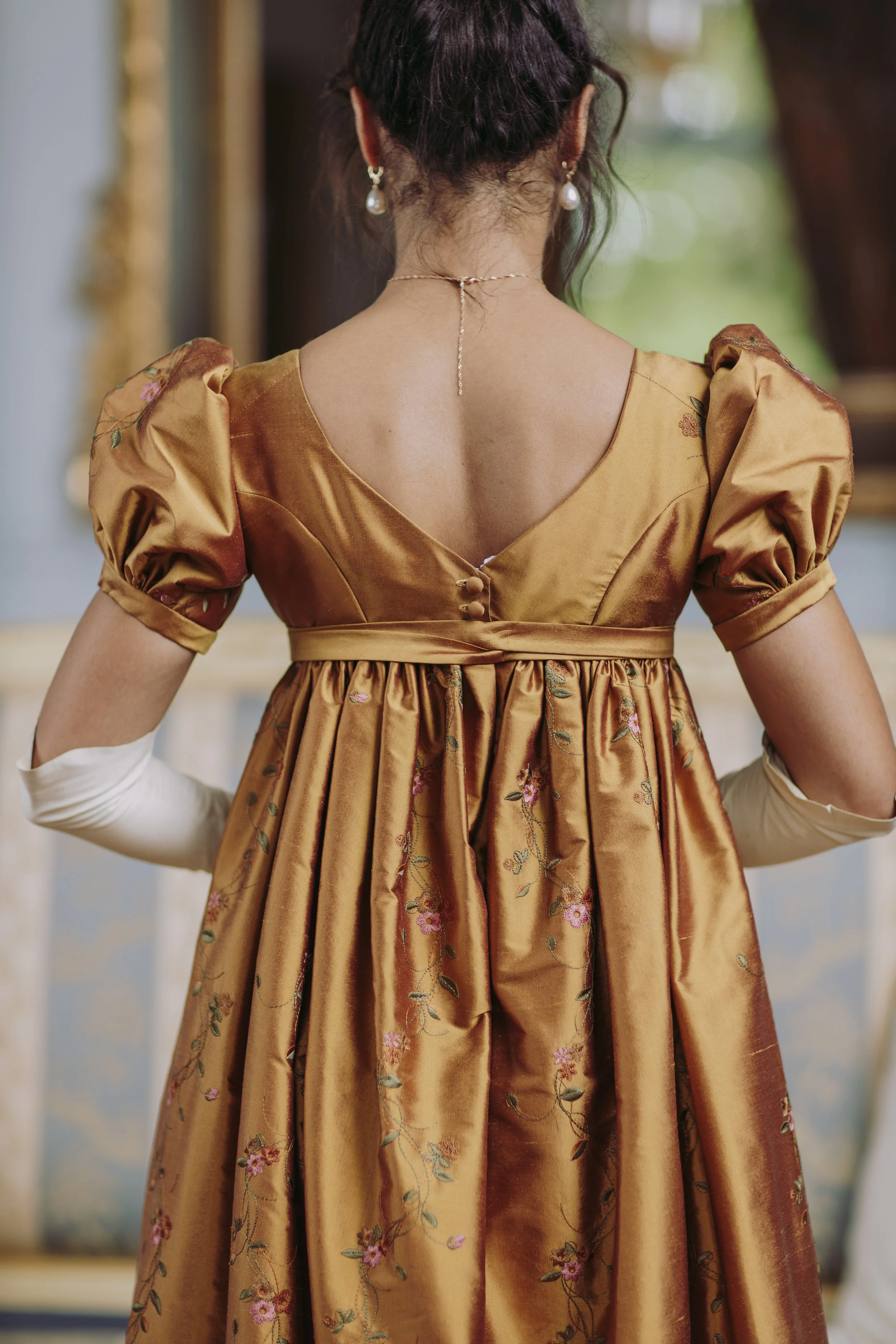 Une femme vue de dos portant une robe premier empire historique 19ème siècle