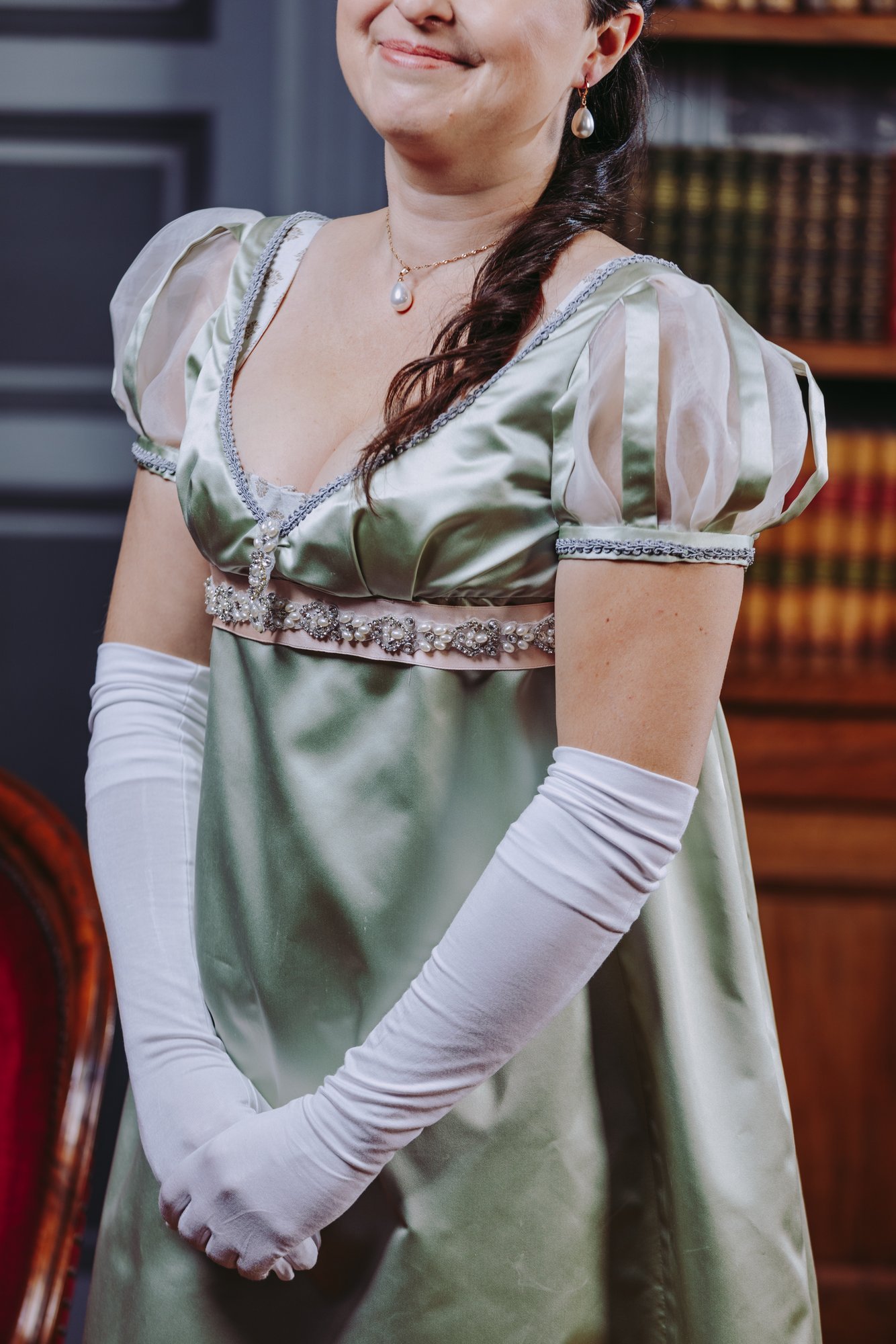 Une femme portant une robe de soirée premier empire historique satin de soie verte costume historique 19ème siècle