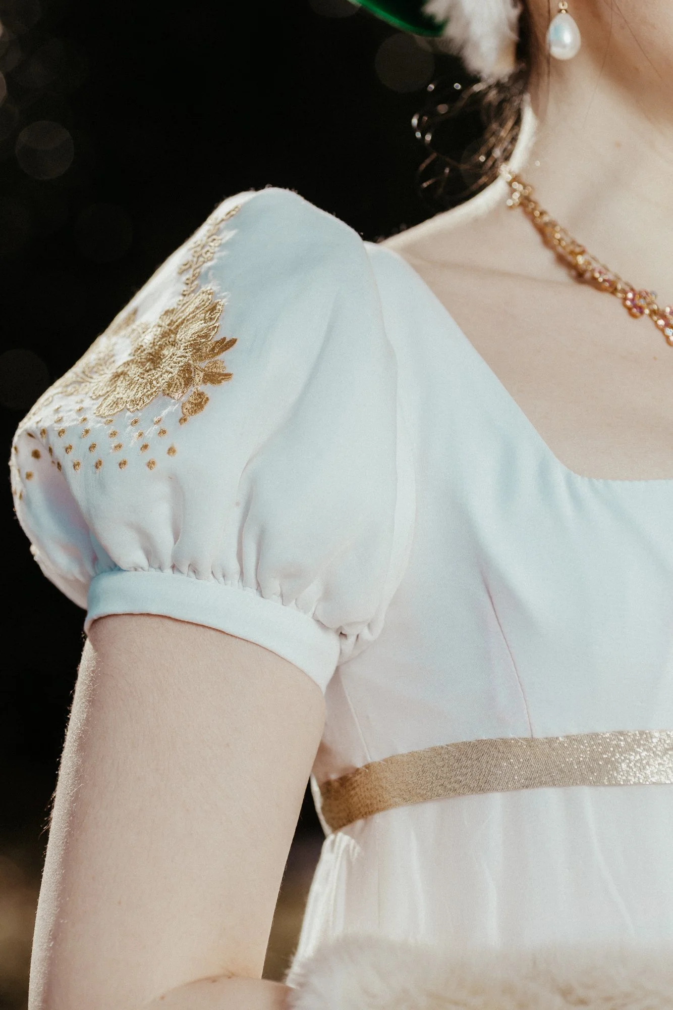 Détail couture d'une manche blanche brodé doré sur une robe historique premier empire 19ème siècle costume robe