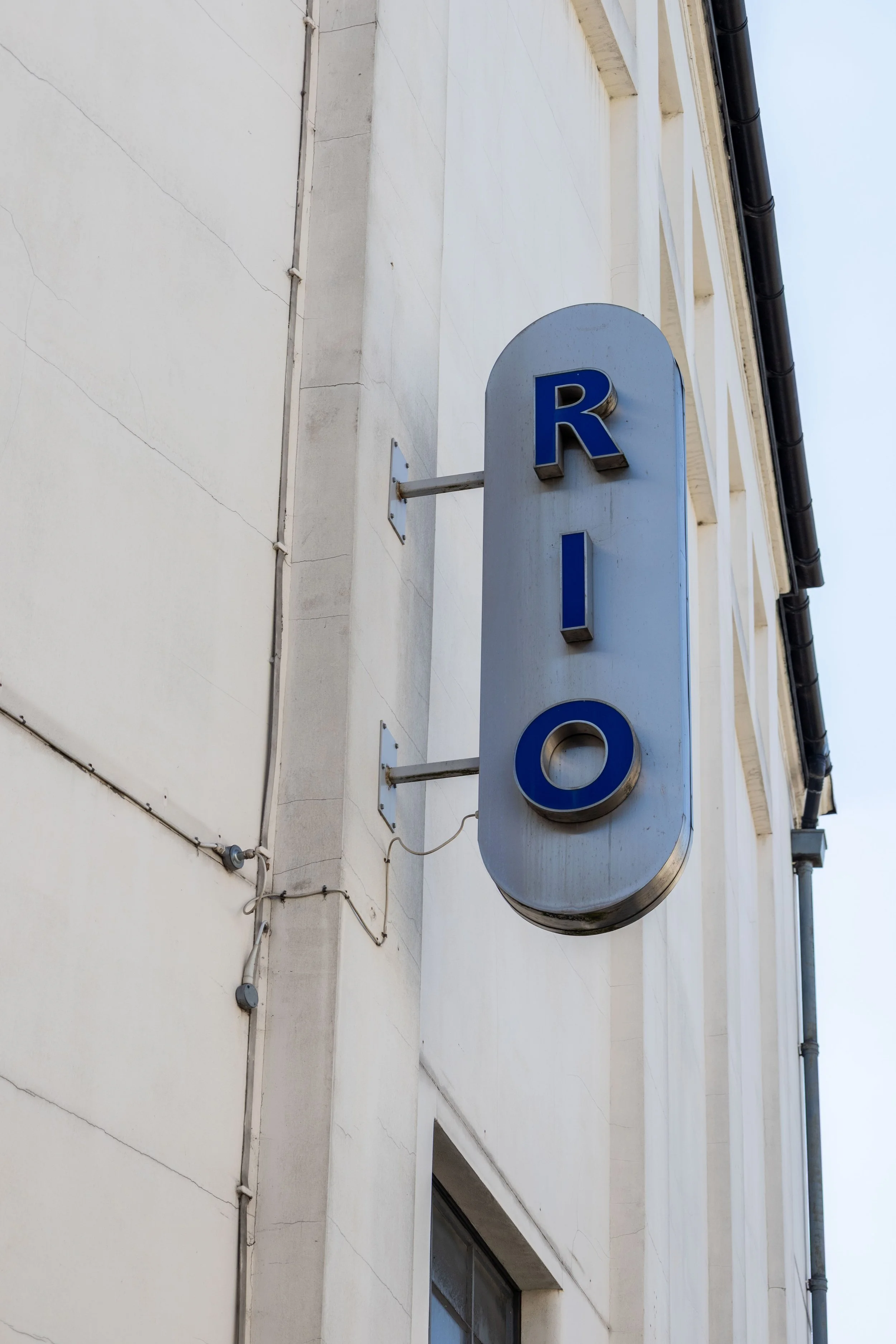 A building with a sign that reads 'ROOM' in large blue letters, mounted on the exterior wall.