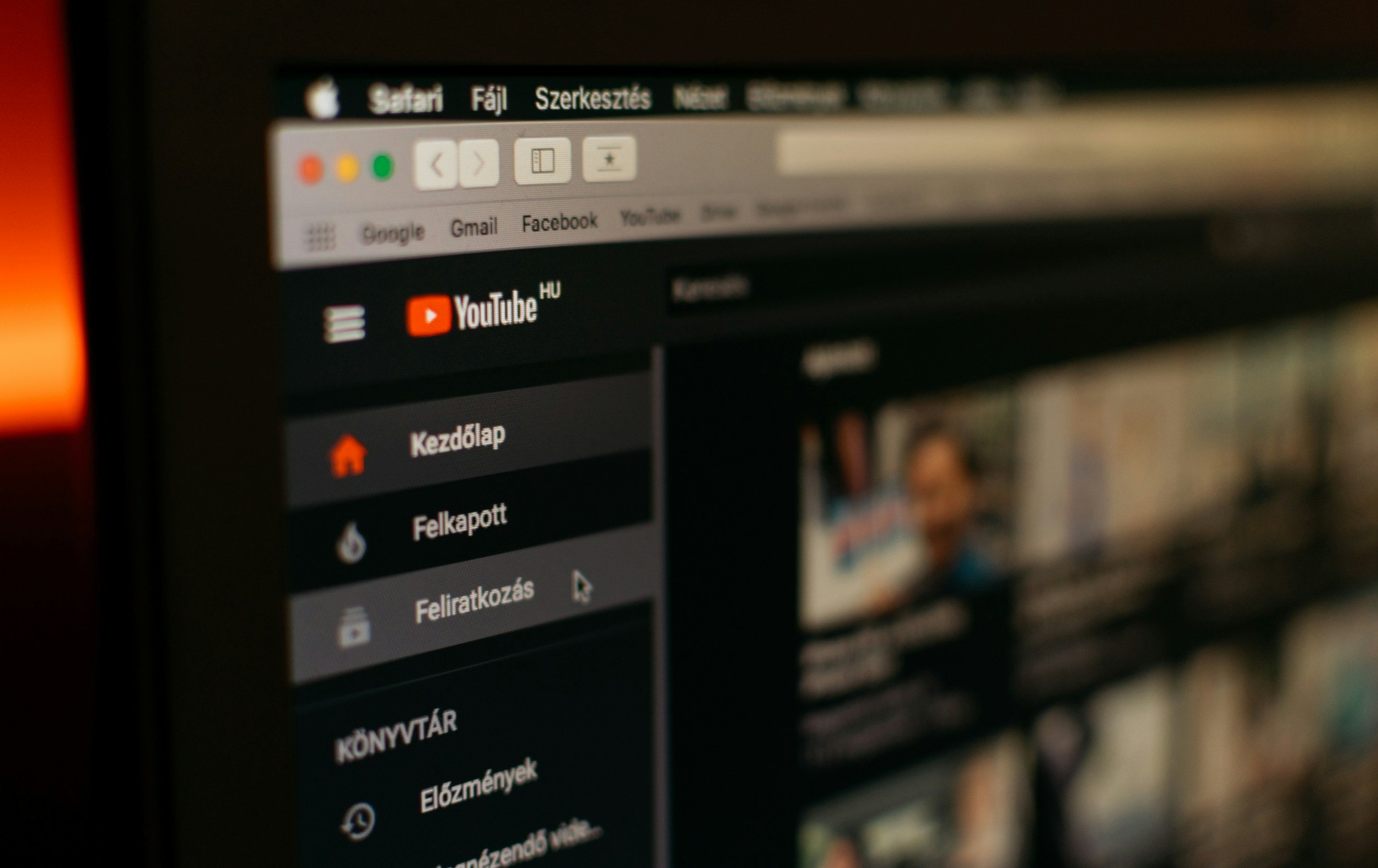 A computer screen displaying a streaming platform with menu options in Hungarian, including 'Kezdőlap,' 'Felkapott,' and 'Könyvtár.' The left side of the screen shows icons and text, and the right side shows part of a video thumbnail. The browser tab has the YouTube logo, and browser controls are visible at the top.