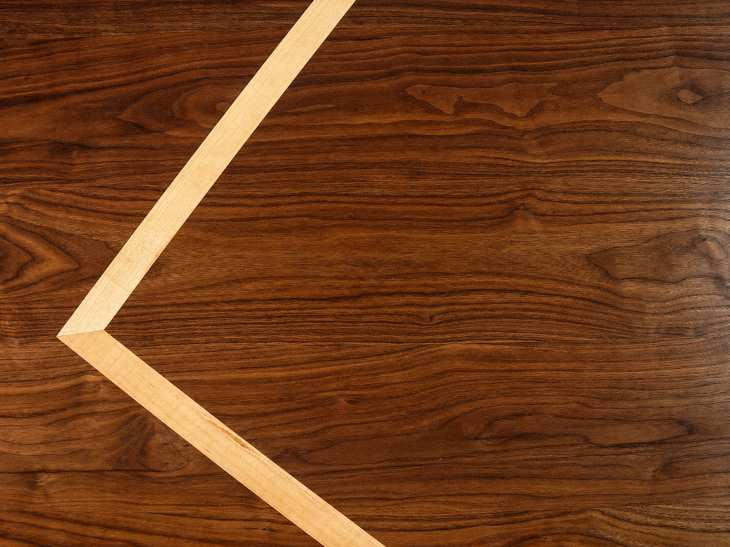 Close-up view of a wooden surface with a light-colored wooden strip forming a partial arrow shape.