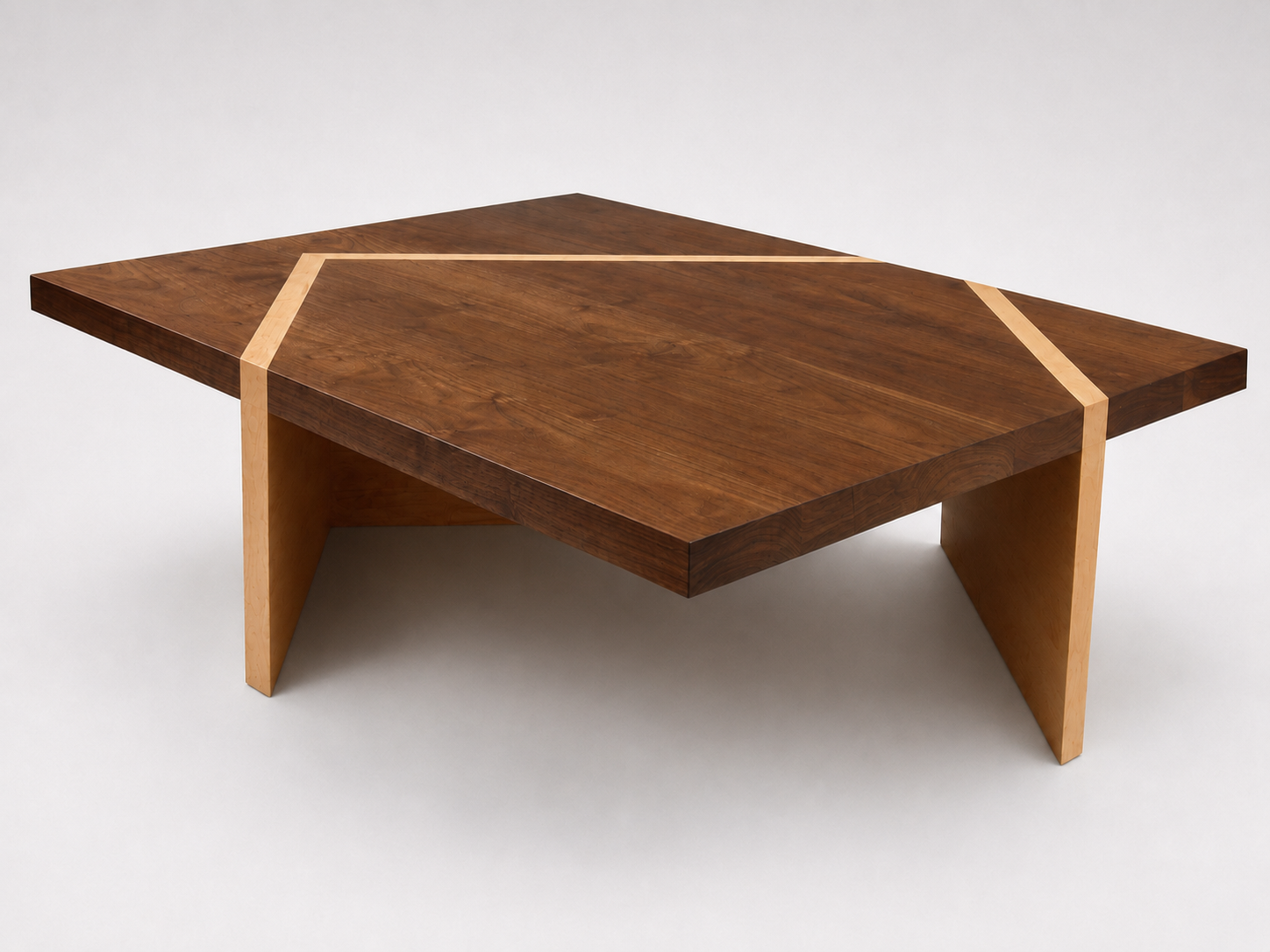A modern wooden coffee table with a geometric design, featuring a dark wood top accented with light wood inlays and matching angled legs.