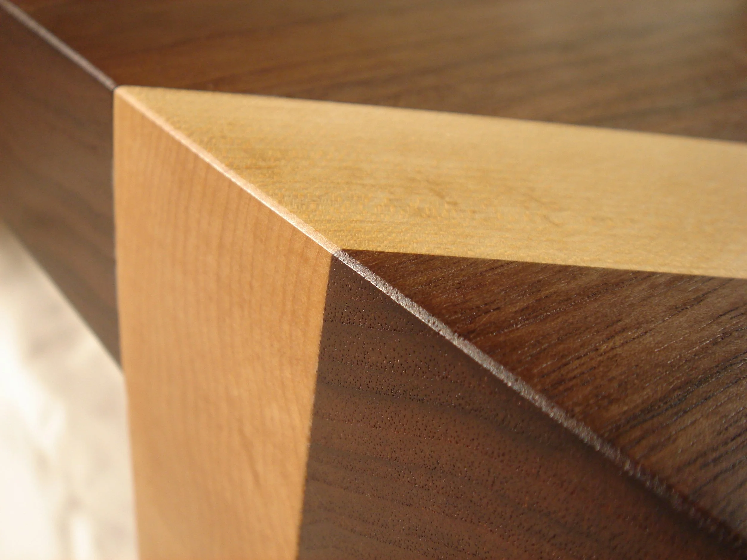 Close-up of several stacked wooden pieces with varying shades of brown, showcasing the grain and edges.