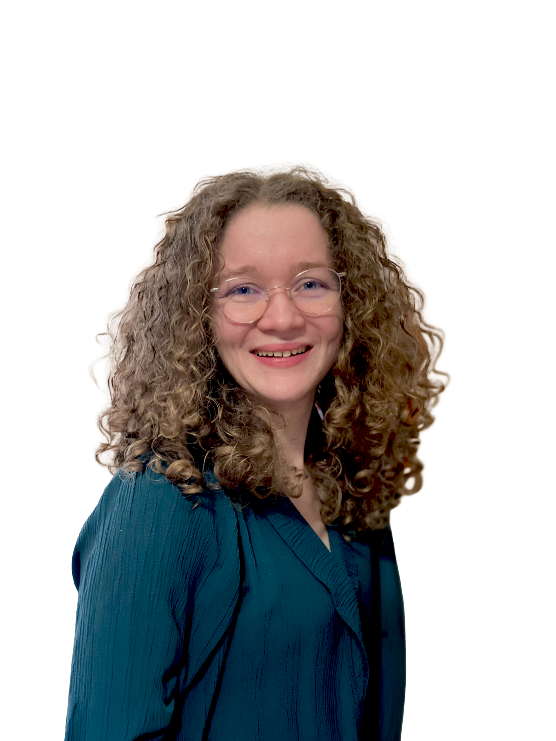 Portret van een lachende vrouw met lang, gekruld haar en ronde bril, gekleed in een blauwe jurk, tegen een neutrale achtergrond.
