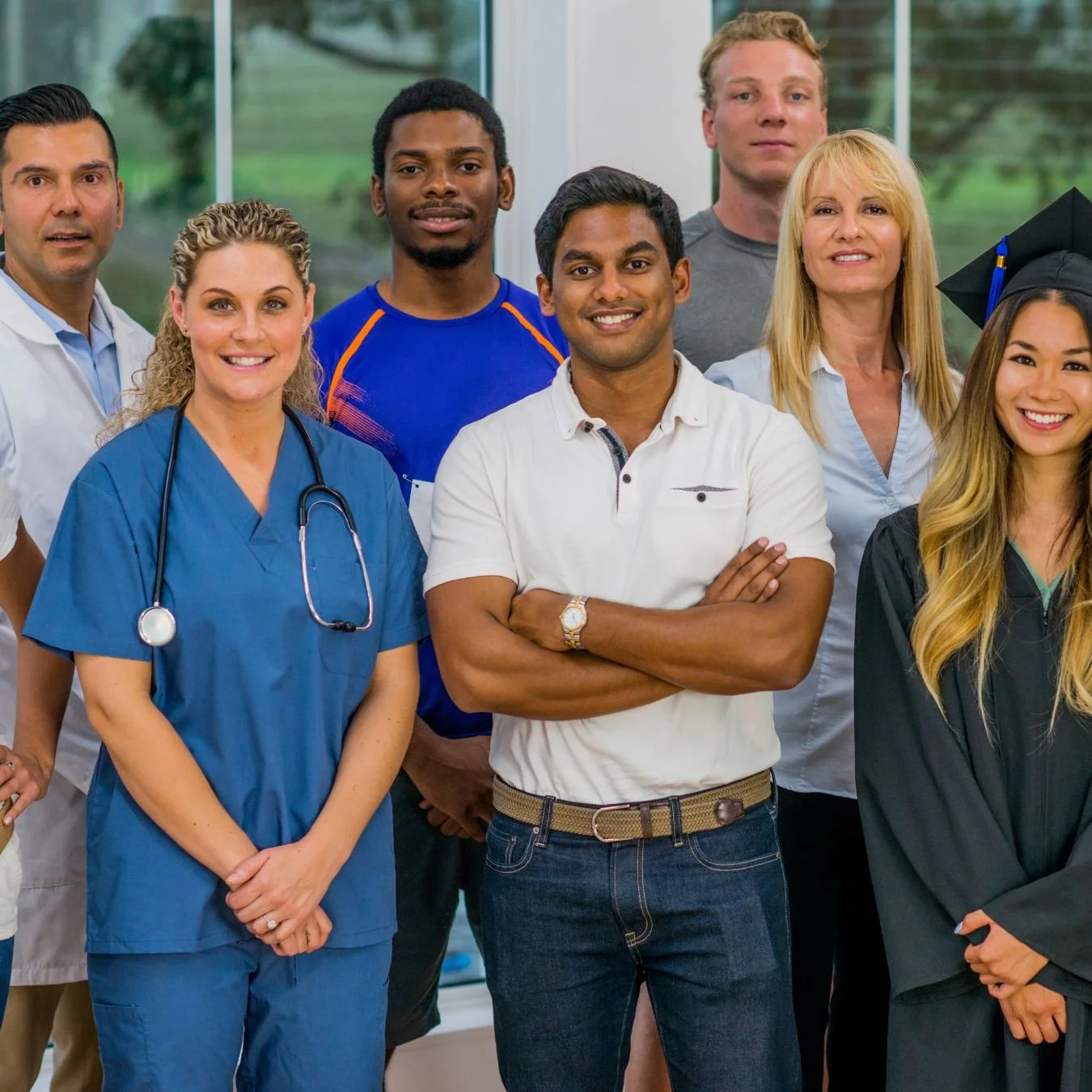 Group of diverse healthcare professionals, including a nurse in scrubs, a doctor in a white coat, and a graduate in a cap and gown, standing inside a hospital or clinic. You can serve God in any profession.