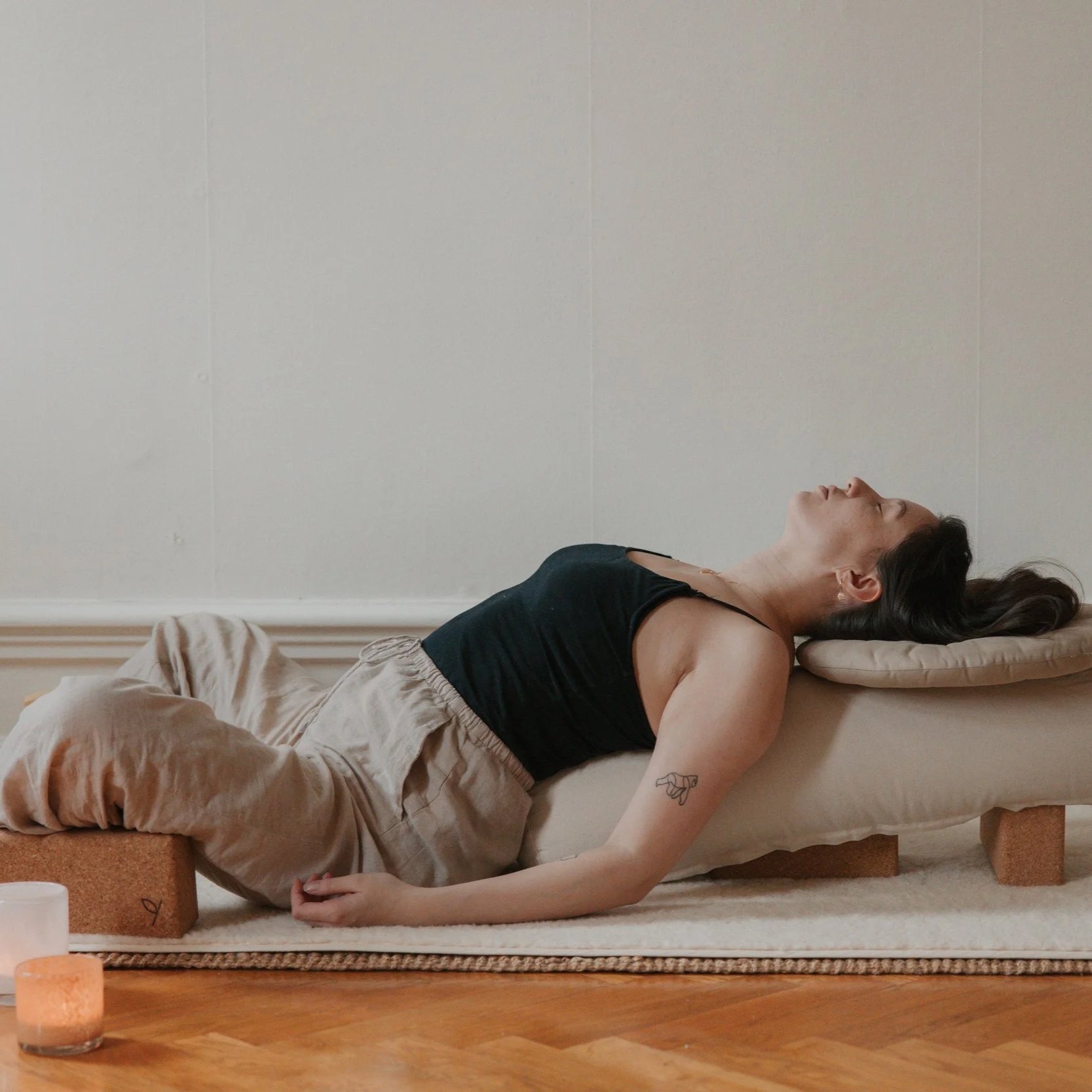 Liv utför en yin yogaposition i en ljus yogastudio