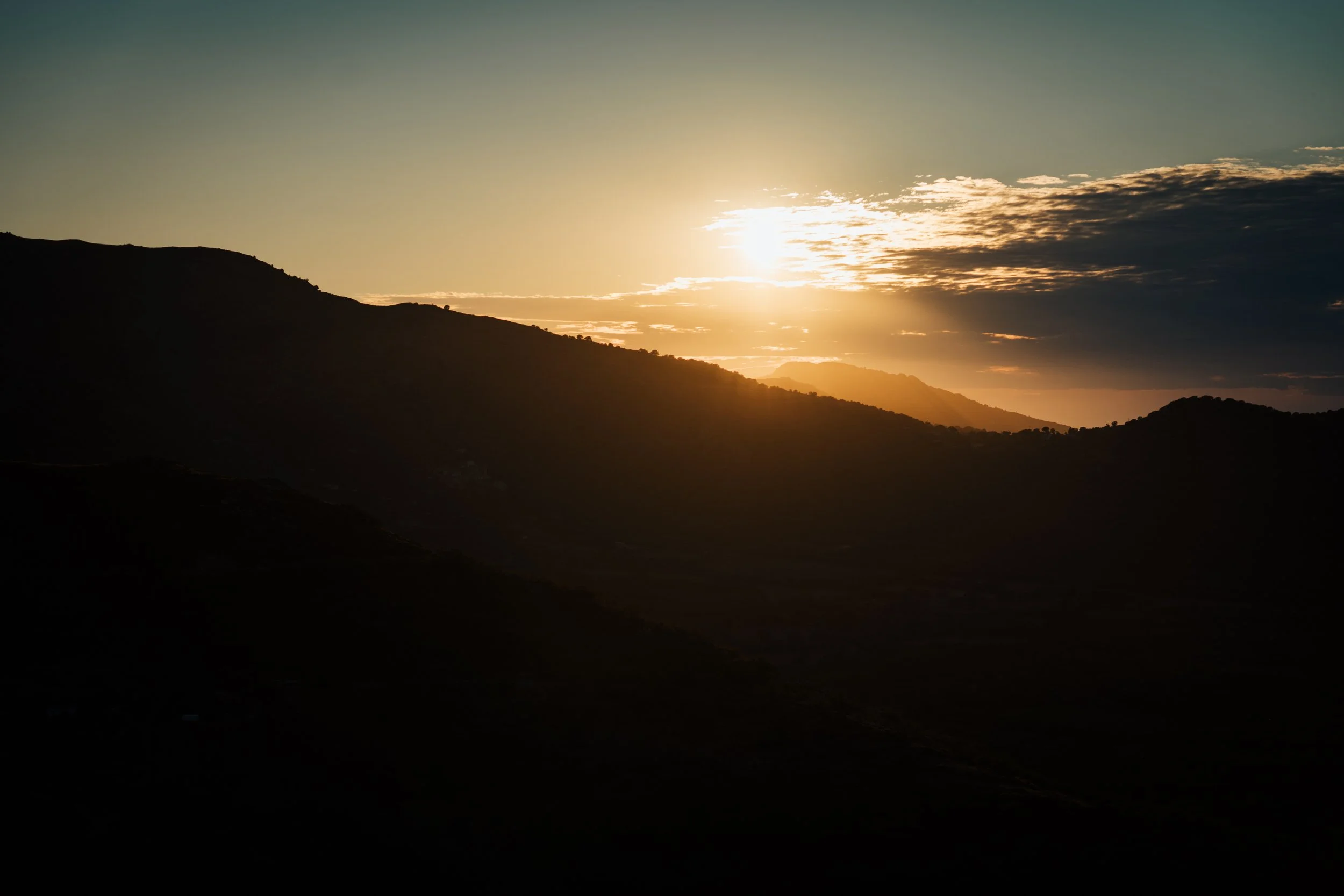 Paysage de montagnes au coucher du soleil avec ciel clair et nuages