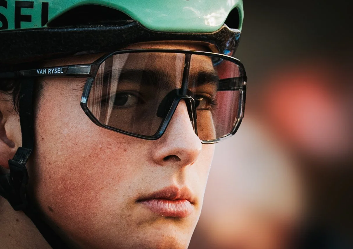 Un jeune homme portant un casque de vélo vert et des lunettes de protection réfléchissantes.
