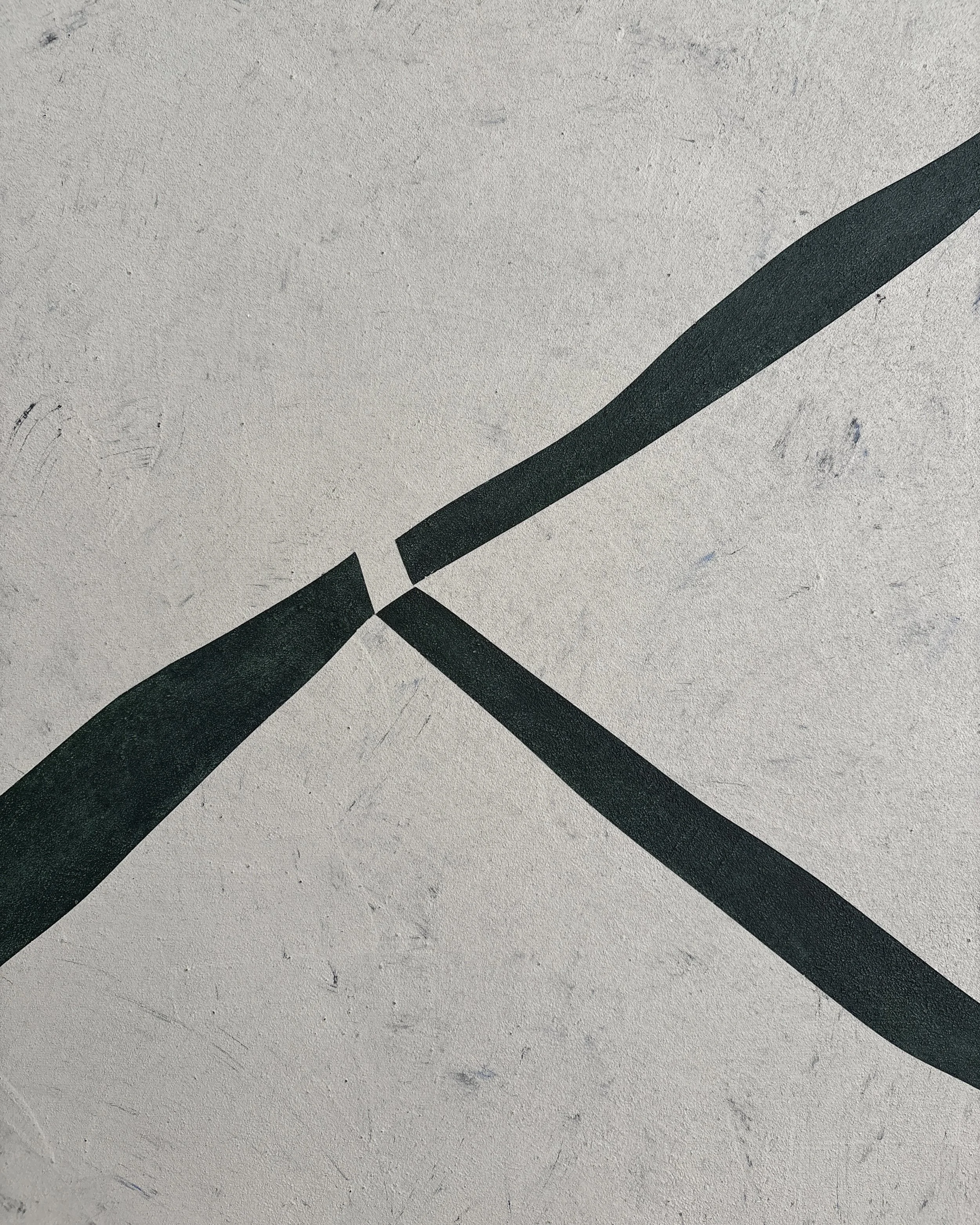 Close-up of Muga by Guillermo Capella, featuring an interrupted junction of dark green-black lines against a textured mineral grey background.