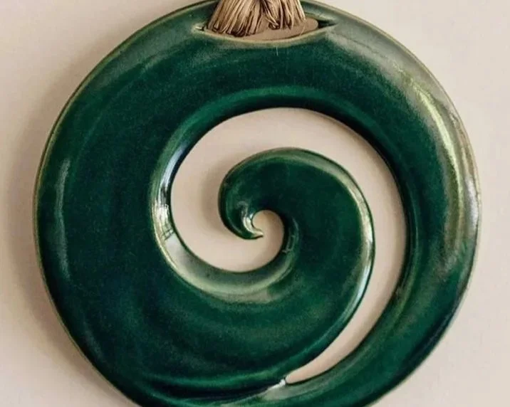 Green spiral-shaped object with a wood piece at the top.