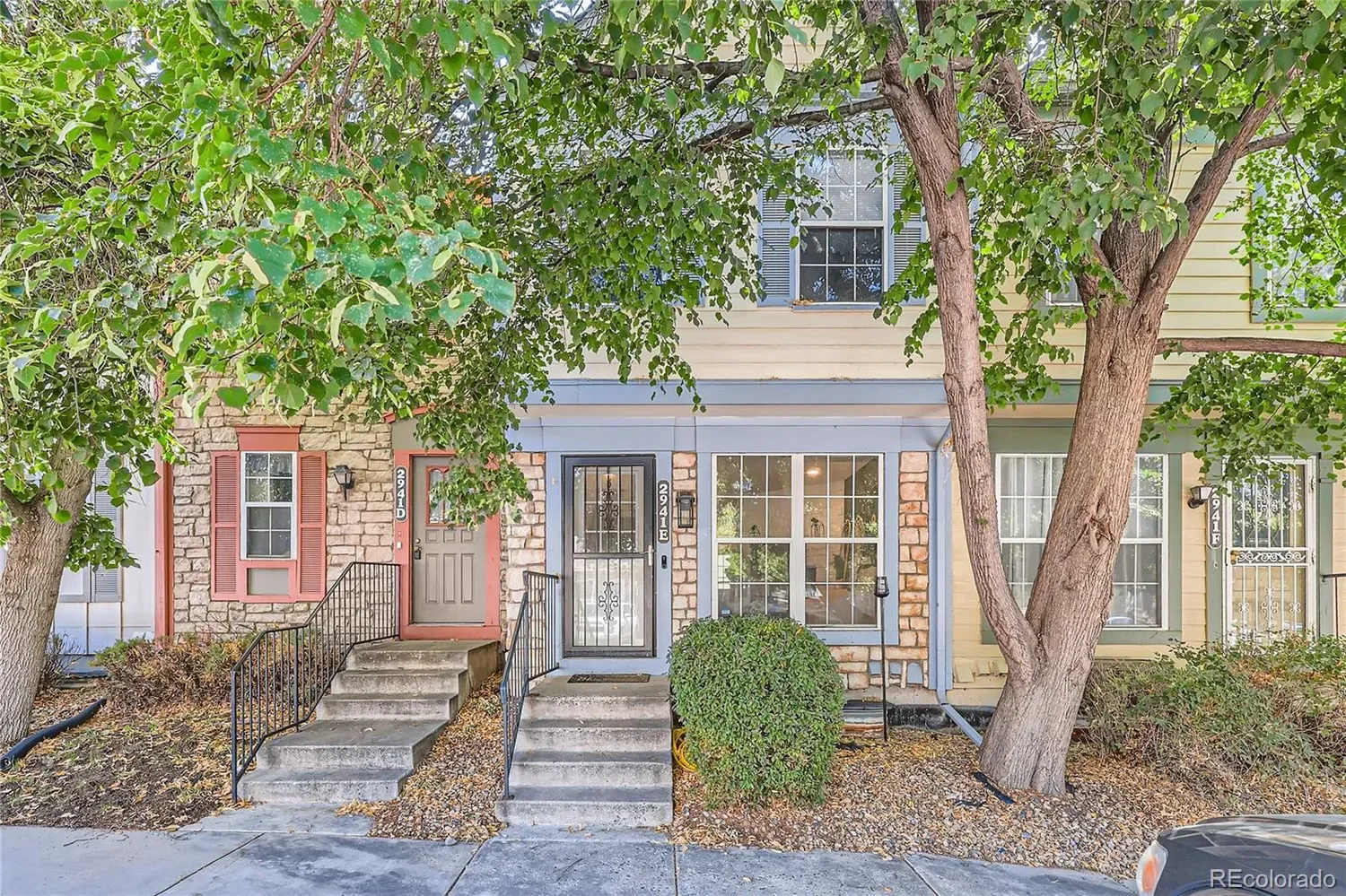 Multi-family row houses with stone and siding exteriors, front steps, and trees in front.  South Denver Realtor serving Highlands Ranch, Lone Tree and Littleton.
