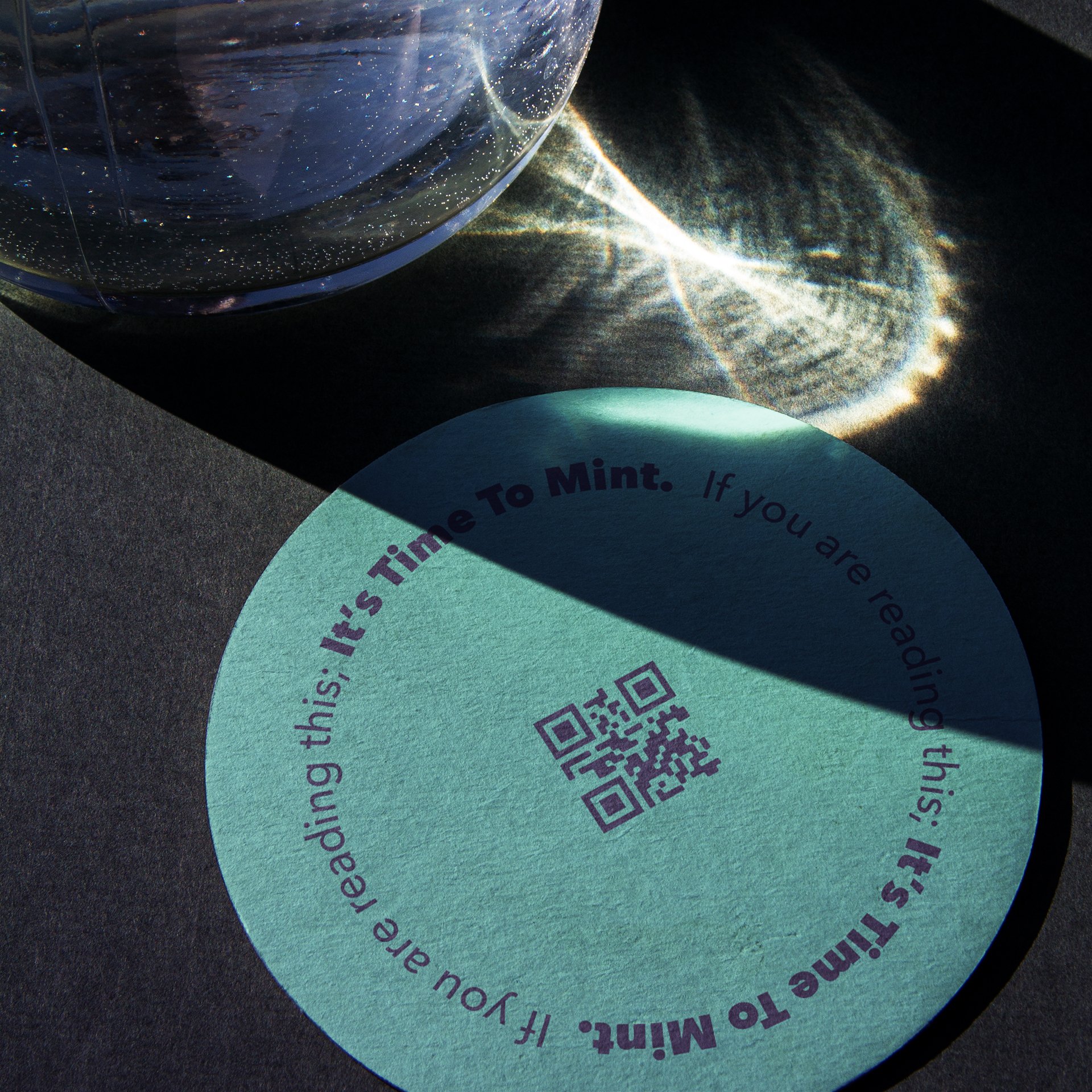 Close-up of a blue circular sticker with a QR code in the center, partially covered in shadow, with purple text written around the edge.