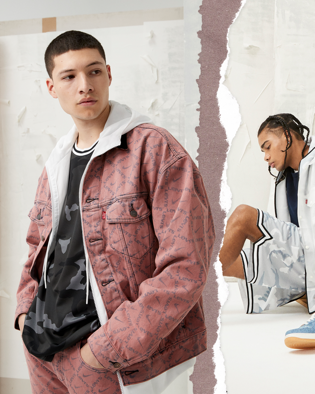 A young man in a pink Levi's denim jacket and camouflage t-shirt, standing against a white wall, looks to his left with a neutral expression. In the background, a young woman with braided hair is sitting on the floor, dressed in a white jacket and shorts, adjusting her shoe.