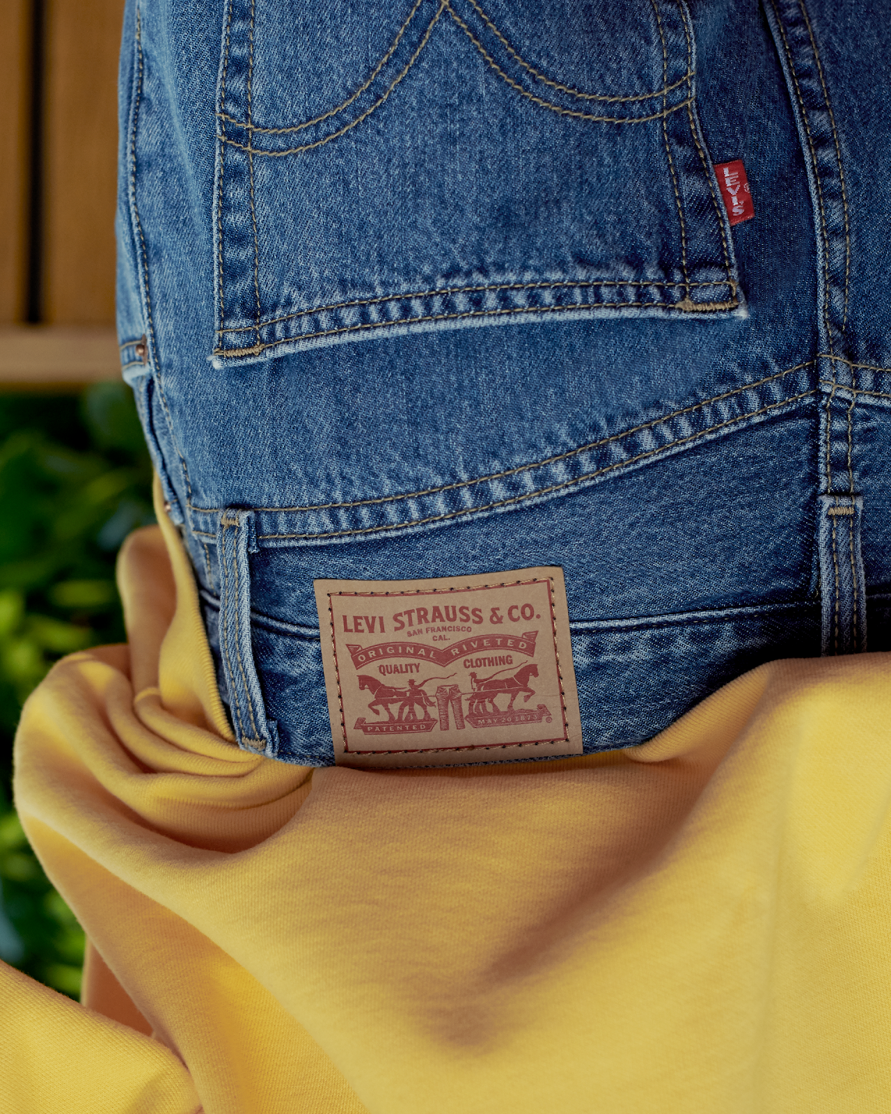 Close-up of a Levi's denim pocket with a leather patch label and a yellow fabric underneath.