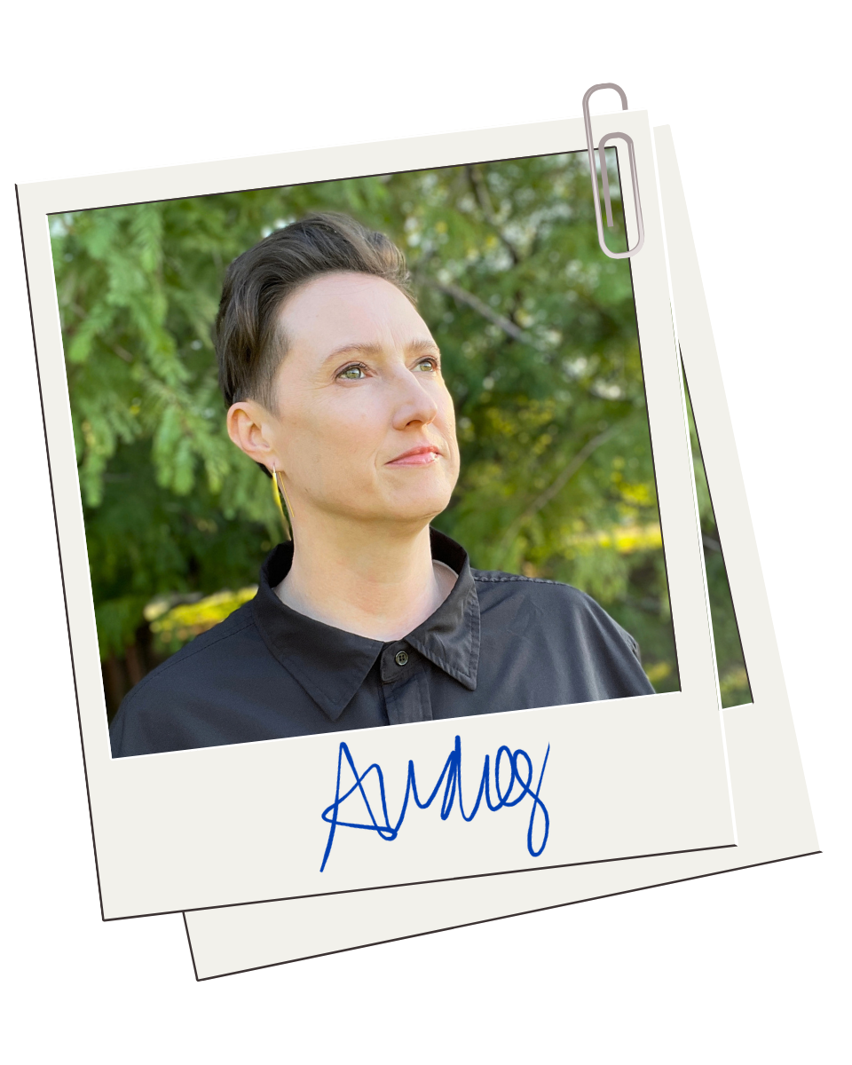 Polaroid of Audrey in a dark collared shirt, looking upward against a backdrop of green trees, with a blue signature below.