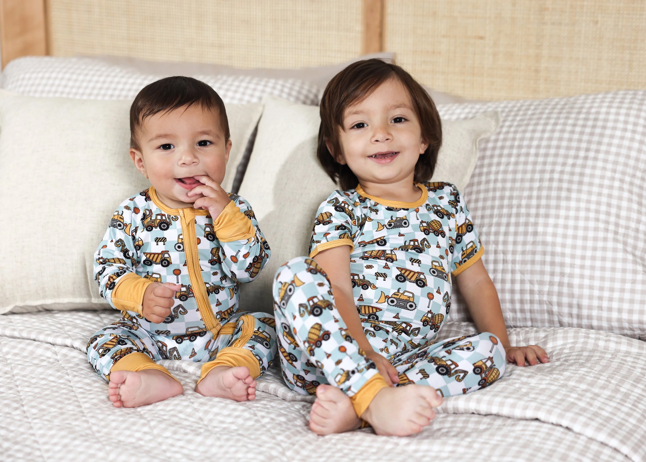 Two young children wearing matching Hardy & Kin Daddy's Helper pajamas with a construction-inspired print.