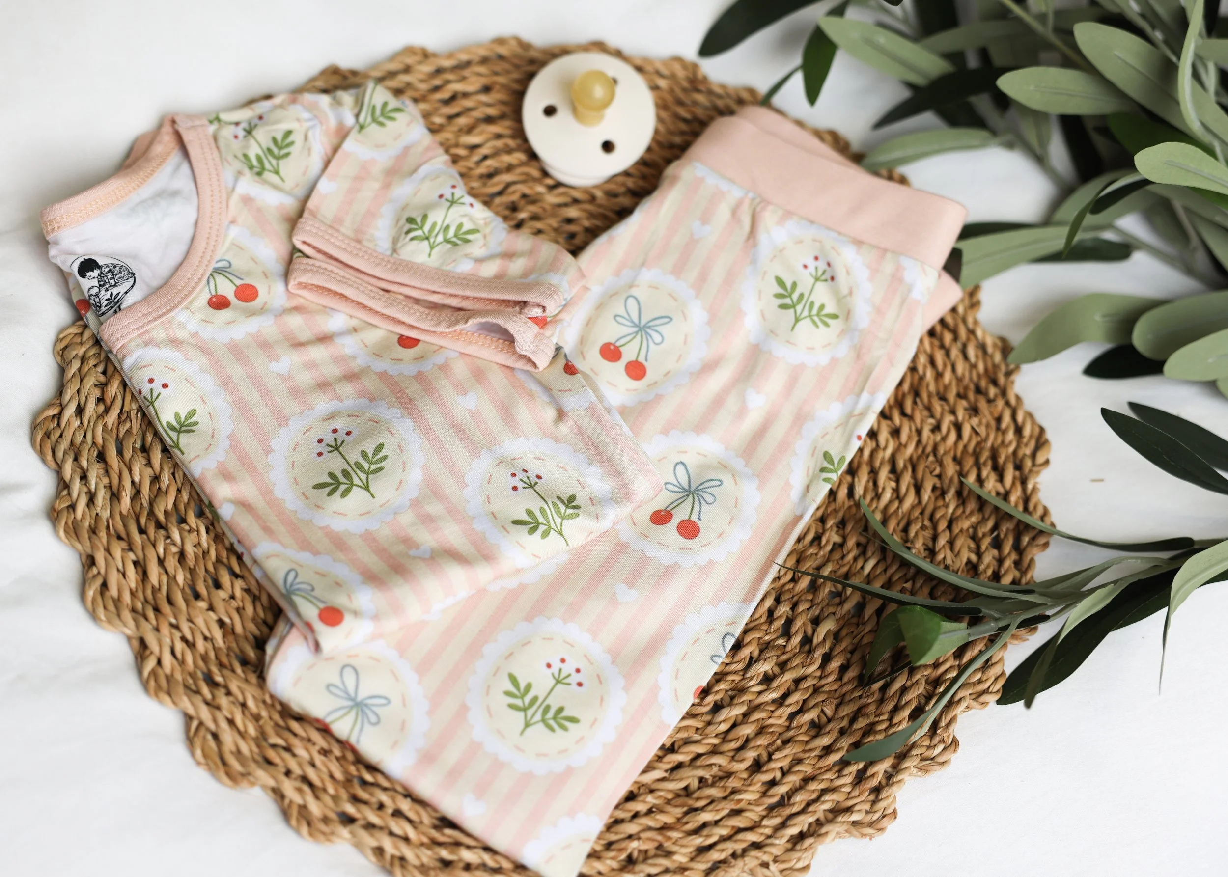 Hardy & Kin Nana's Garden baby sleepwear featuring a floral and cherry-inspired print.
