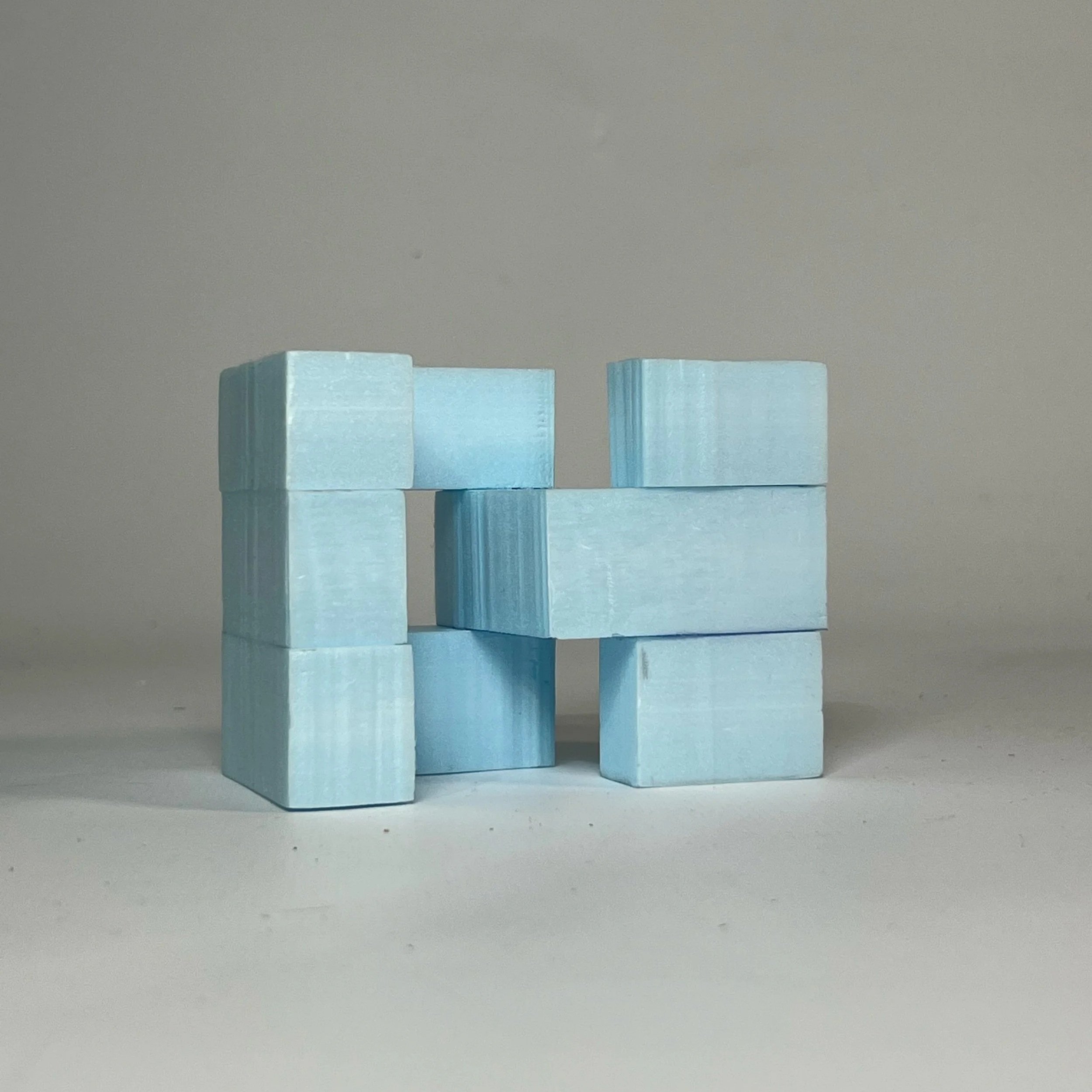 Light blue modular block study arranged as an interlocking form.