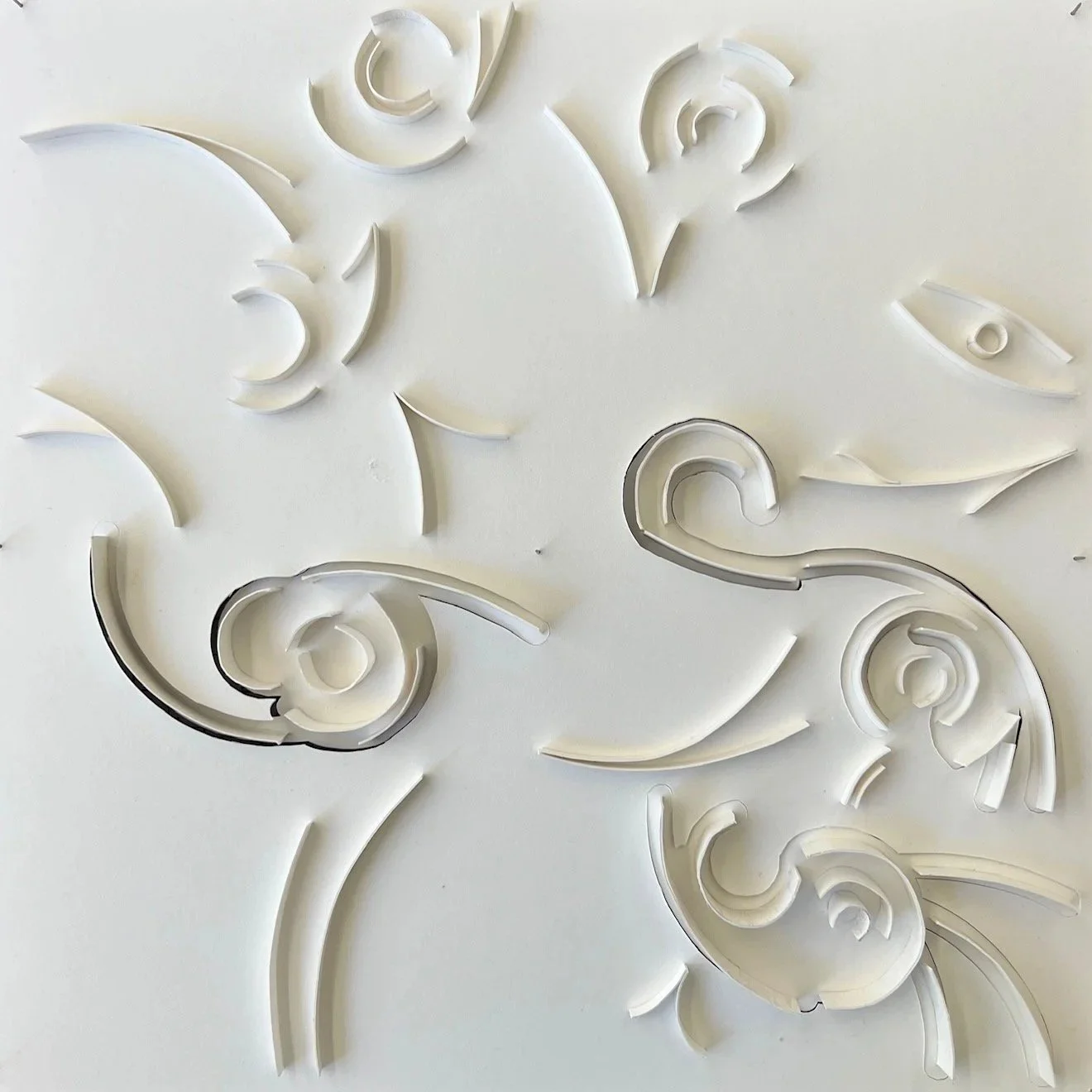 White abstract wall relief with curved organic cutouts.