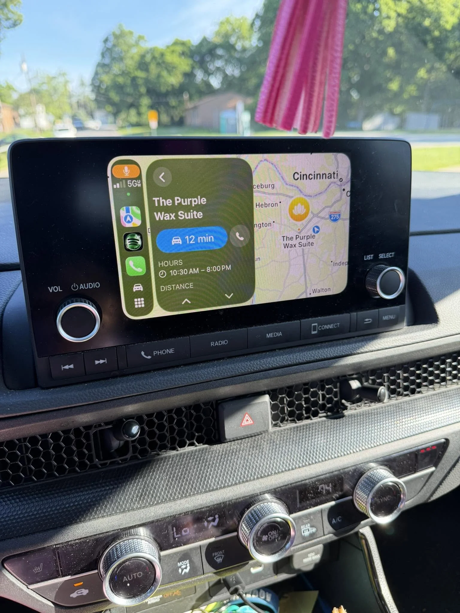 Car dashboard with a GPS screen displaying route to The Purple Wax Suite in Florence, Kentucky