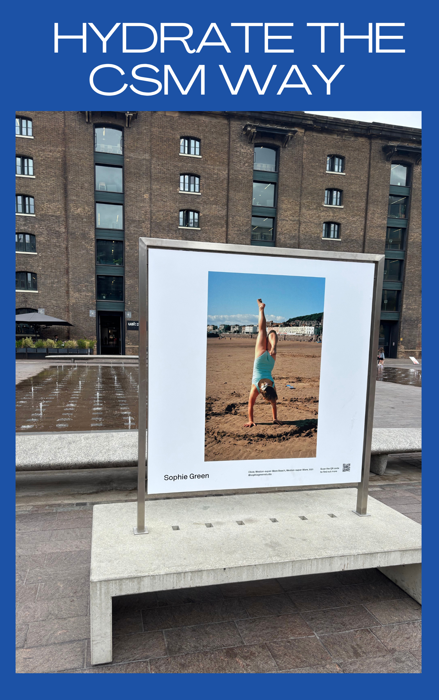 Photograph of a large outdoor display with a picture of a woman doing a handstand on the beach, wearing a blue tank top and shorts, with a cityscape and hills in the background. The display has the name 'Sophie Green' and details about the location a