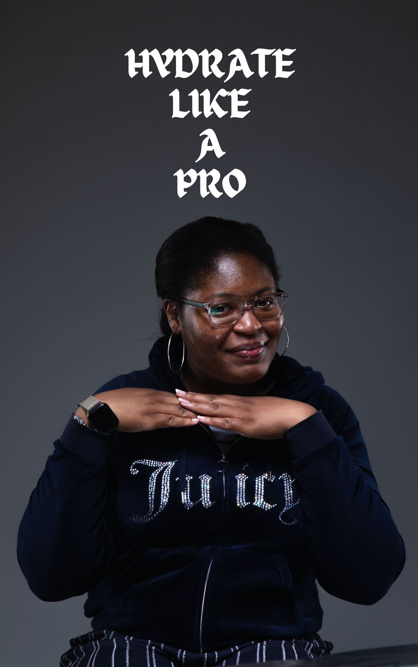 A woman with dark hair, wearing glasses and hoop earrings, smiling with her hands resting under her chin, in front of a dark background, with white text above her head that reads 'HYDRATE LIKE A PRO'.