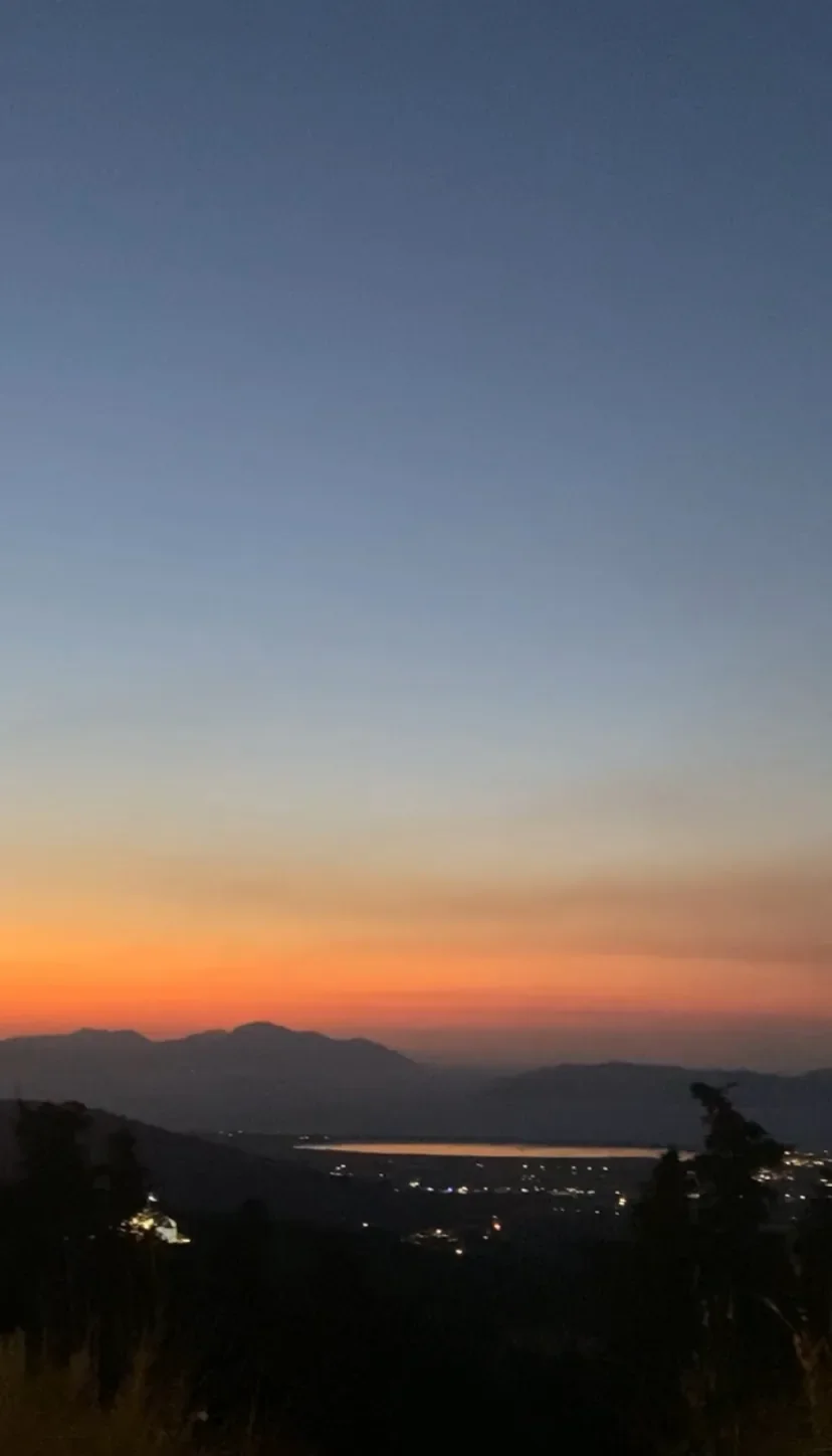 A soft sunset over distant hills and water